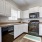 Spacious and well lit kitchen with wood floors and stainless steel appliances 