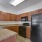Spacious and well lit kitchen with wood floors and stainless steel appliances 
