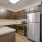 Spacious and well lit kitchen with wood floors and stainless steel appliances 