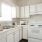 Spacious and well lit kitchen with wood floors and white appliances 