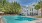 Large sparkling blue pool with large pool deck 