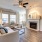 Spacious and well lit living room with wood floors and a large window with access to the kitchen