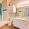 Large well lit bathroom with white cabinents